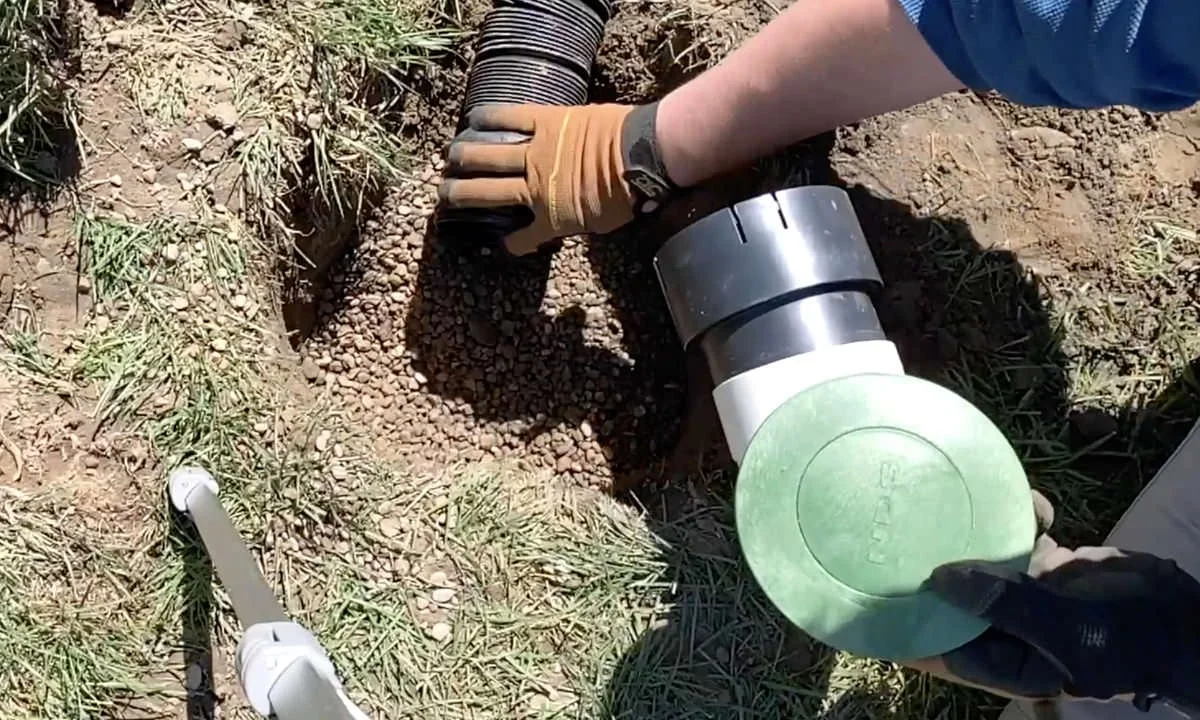 Pop-up drain emitter installed flush in a Houston TX residential lawn